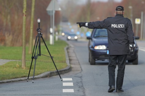 Polizist winkt ein PKW heraus bei einer Geschwindigkeitsmessung mit einem Lasergerät TraffiPatrol, Modell Traffipax der Fa. Jenoptik